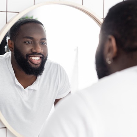 Man smiling at reflection in mirror