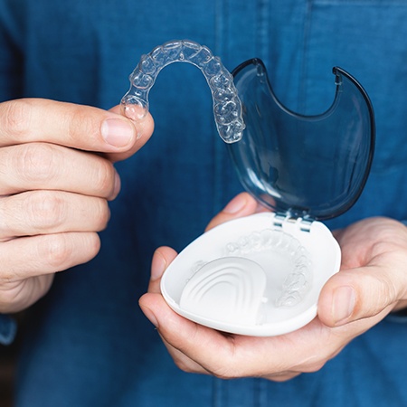 Man holding Invisalign tray and case 