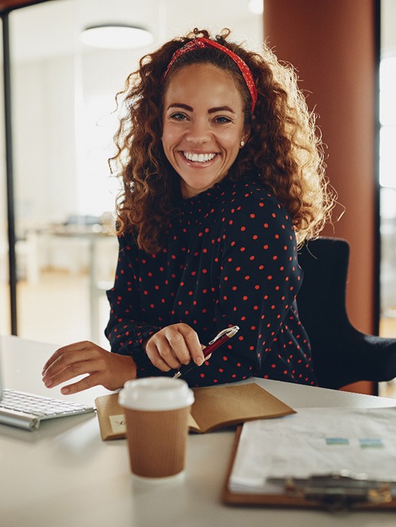 Woman smiling while working at desk in office