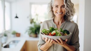 Smiling middle-aged woman holding a colorful salad